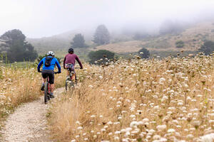 Two cyclists mountain biking a trail in Rancho Corral de Tierra