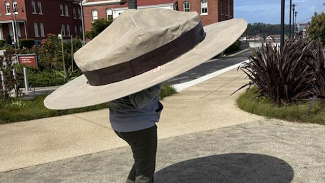 Person wearing an oversized a NPS park ranger flat hat.