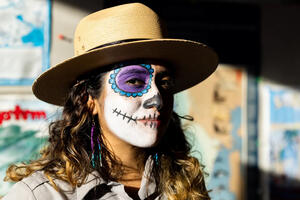 A portrait of an  NPS ranger with candy skull face paint on for Dia de los Muertos.