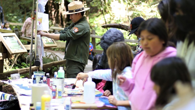 NPS Ranger hangs up watercolor art.