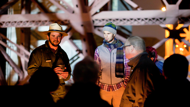 NPS park ranger gives a candlelight tour to guests at Fort Point