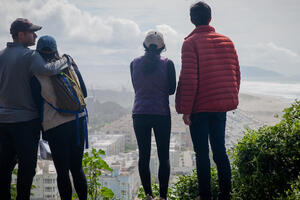Four people stand on edge of Sutro Heights Parks looking out towards Ocean Beach and Golden Gate Park