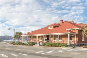 Image of the front of the Presidio Visitor Center with the Golden Gate Bridge in the backgrounr