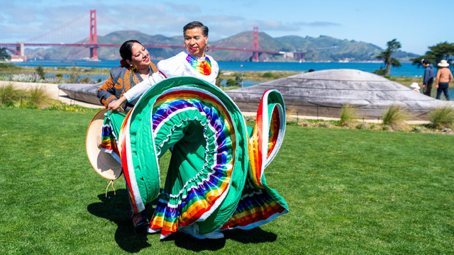Two dancers performing at Presidio Tunnel Tops with a golden gate bridge view.
