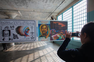 Woman takes photo of Future IDs display in the New Industries Building on Alcatraz.