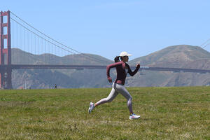 Laura Yin running at Crissy Field with the Golden Gate Bridge in the background.