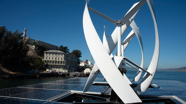 View of wind turbines and solar panels from atop an Alcatraz cruises boat.