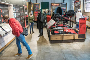 Visitors examine information about incarceration on red and black panels at Alcatraz.