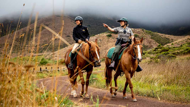 Lainie Motamedi, left, and Park Ranger Katlyn Grubb ride out from the Horse Mounted Patrol Stables in the Marin Headlands.
