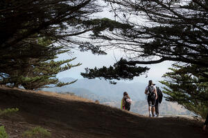 People hiking down a winding path at Rancho Corral de Tierra.