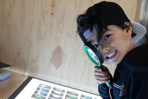 Youth with magnifying glass at Presidio Tunnel Tops