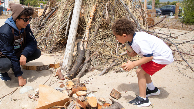 An Adventure Guide engages with a young person at the Outpost at Presidio Tunnel Tops.