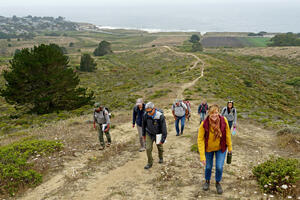 A group hikes up a path at Rancho Corral de Tierra.