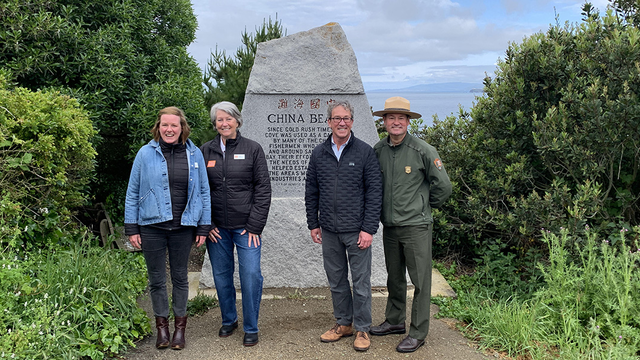 Park leaders stand in front of the China Beach monument.