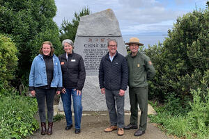 Park leaders stand in front of the China Beach monument.