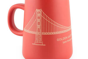 Red and gold tapered mug with a line drawing of the Golden Gate Bridge.