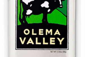 A metal tin with the image of a cow standing in a grassy hillside