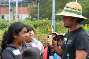 Students check out a California poppy being grown at a nursery.