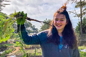 Crissy Field Center IYEL intern in nature holding a hemlock root