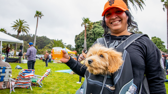 A woman poses with her dog at the Parks4All: Brewfest in the Presidio.