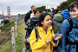 middle schoolers hike on coastal bluffs with golden gate bridge