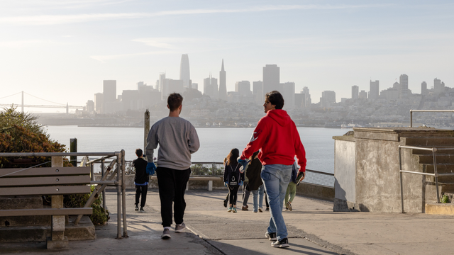 Students walk amid the San Francisco skyline on their way to Alcatraz Historic Gardens to volunteer.