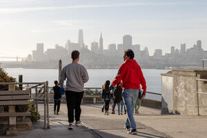 Students walk amid the San Francisco skyline on their way to Alcatraz Historic Gardens to volunteer.
