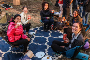 Five friends sitting outside at Sutro Heights Park holding up Fort Point Beer cans.