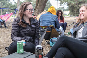Two women sitting outside in the middle of a conversation.