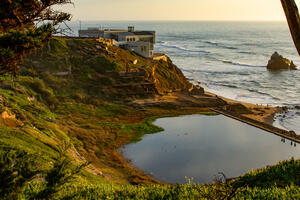 A sunset view overlooking Lands End, the ruins of Sutro Baths, and the ocean.