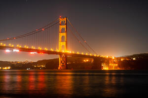 The Golden Gate Bridge lit up at night.