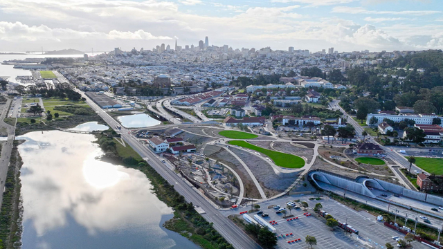 An aerial view of the Presidio Tunnel Tops, looking out to the San Francisco city skyline.