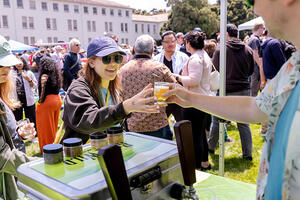 Buck Wild Brewing hands event attendee a tasting glass full of beer at Parks4All: Brewfest, a beer festival and fundraiser, on Saturday, July 29th, 2023 in the Presidio of San Francisco.