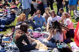 A group of friends sitting on a picnic blanket at Parks4All: Brewfest, a beer festival and fundraiser, on Saturday, July 29th, 2023 in the Presidio of San Francisco.