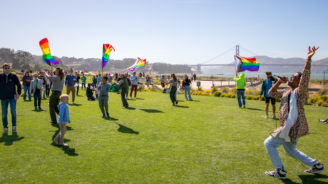 Park visitors dancing, singing, and celebrating at Pride in the Presidio, San Francisco.