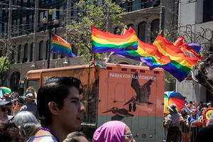 Roving Ranger van with pride flags waving on its roof.