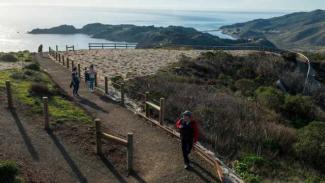 Hikers explore a newly built segment of the Hawk Hill Trail