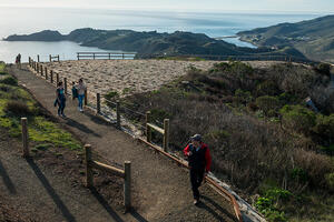 Hikers explore a newly built segment of the Hawk Hill Trail