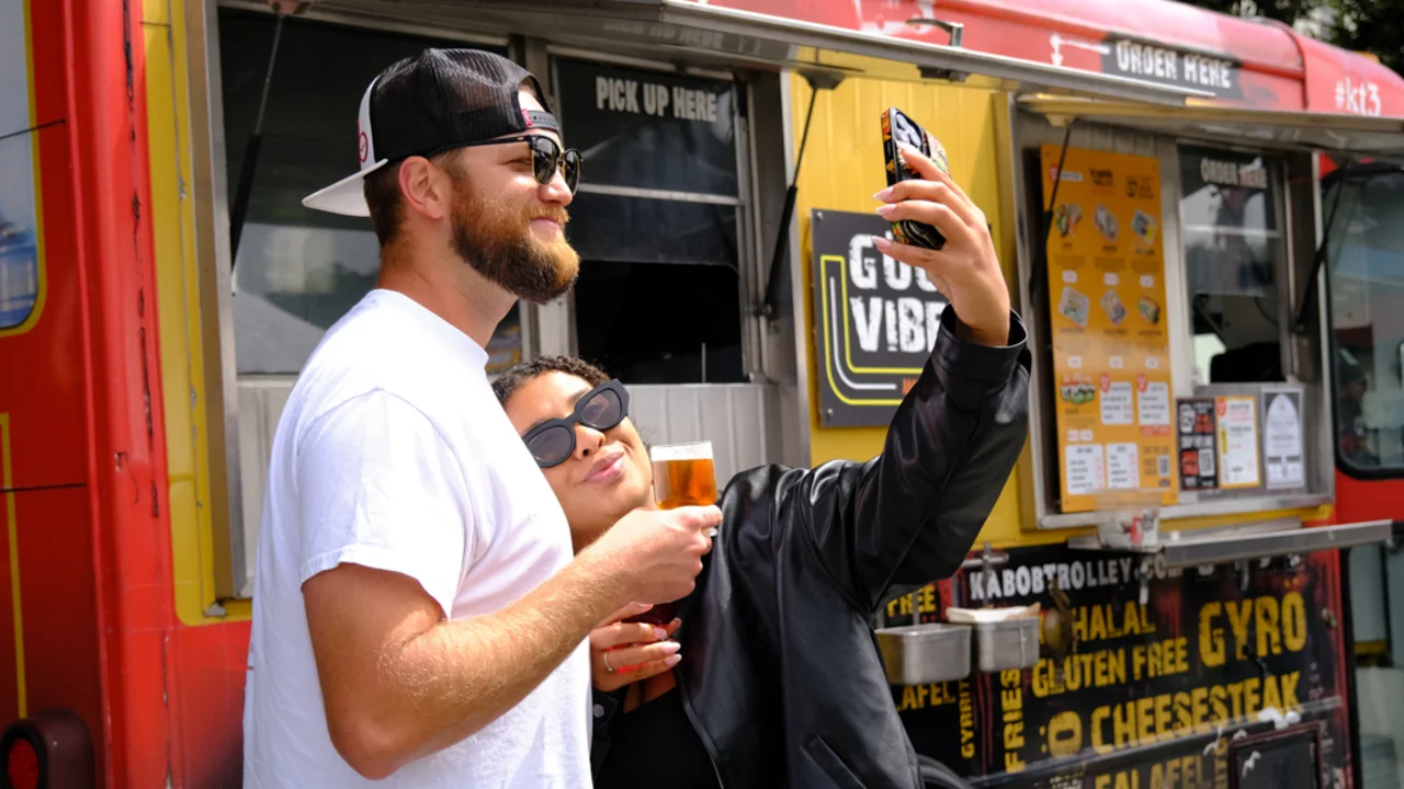 A couple poses for a selfie in front of a food truck at Parks4All: Brewfest in the Presidio of San Francisco
