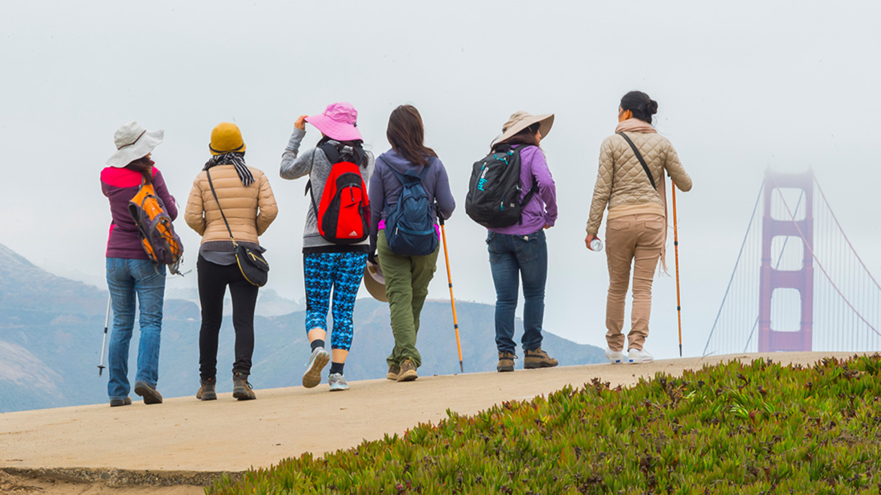 A group of people gather near the Golden Gate Bridge