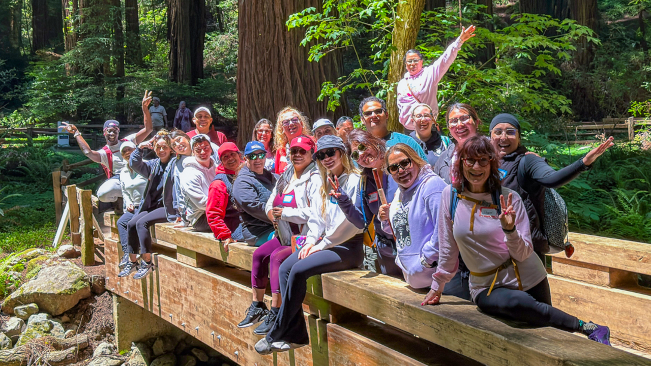 ALAS (Ayudando Latinos A Soñar) participants in a group photo on a wooden bridge at Muir Woods.