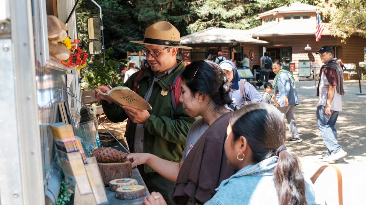 A ranger and park program participants examine interactive items.