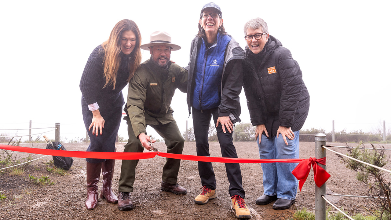 Four people at a ribbon-cutting event for the completion of the Hawk Hill Visitor Improvement Project