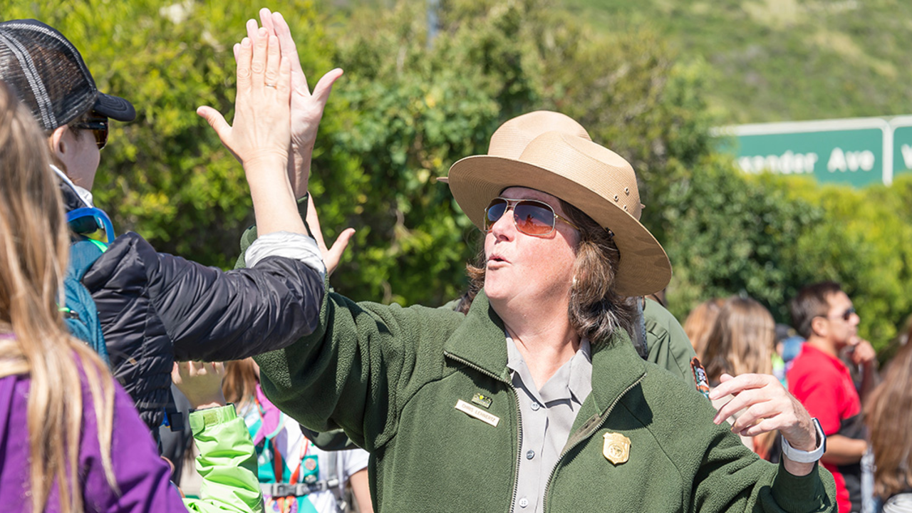 GGNRA Superintendent Christine Lehnertz high-fives a park visitor.