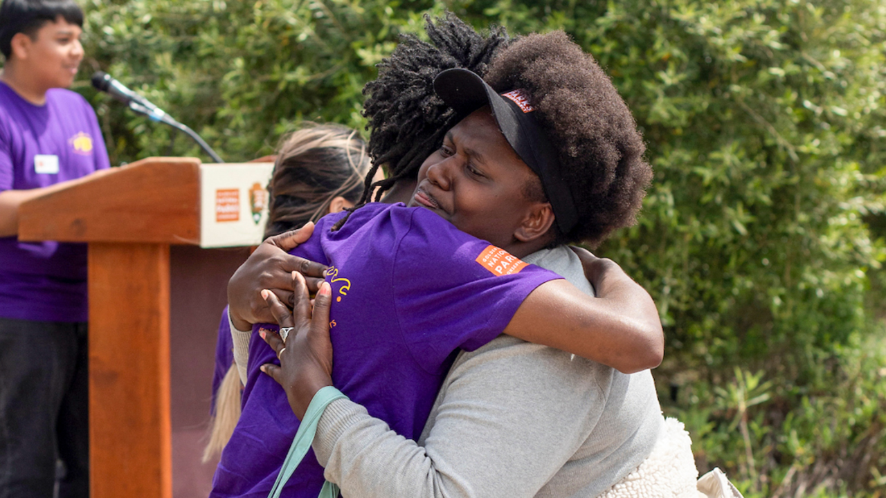 A woman proudly hugs a youth participant during the Goldman Prize Awards Youth Reception at Crissy Field Center in the Presidio.