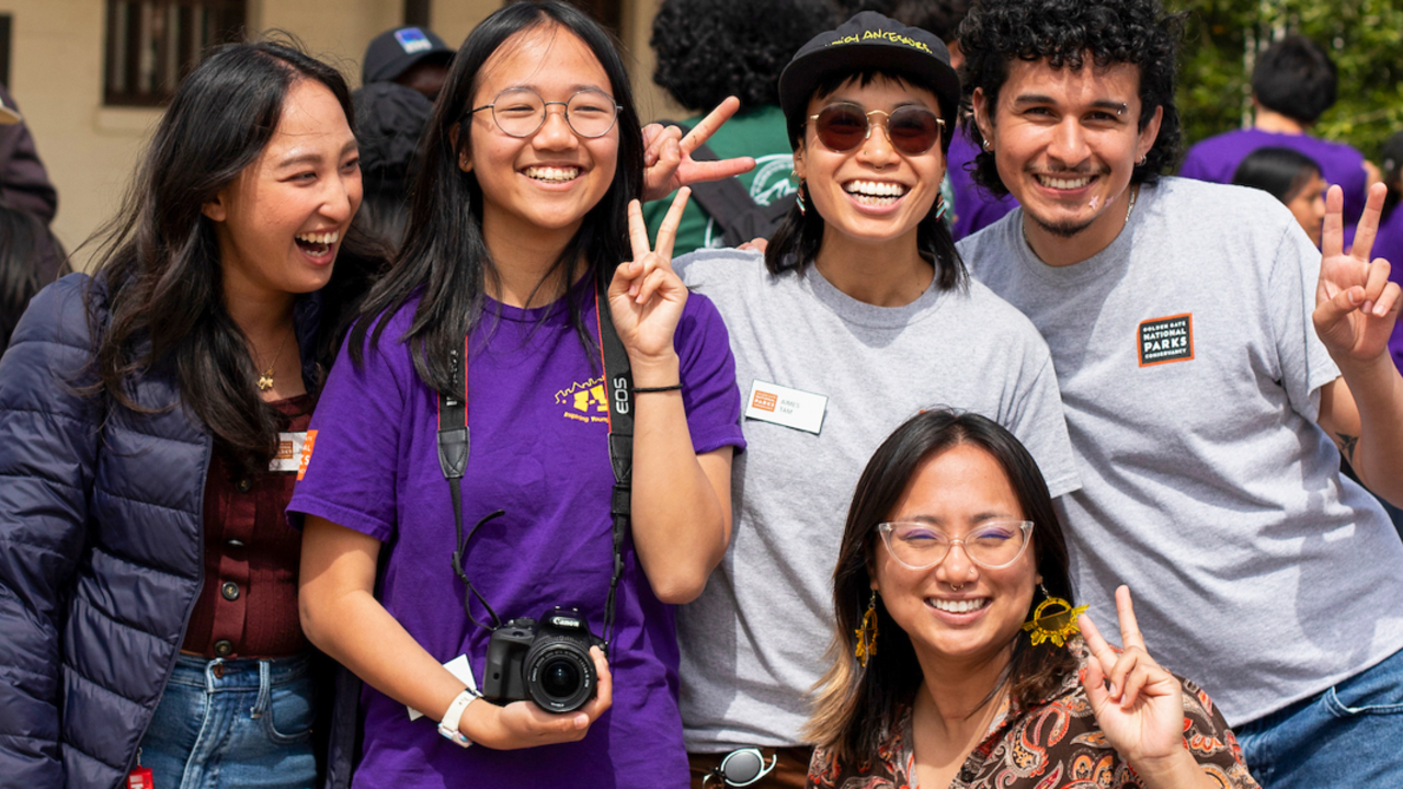A group of Parks Conservancy staff and youth program participants pose for a group photo at Crissy Field Center.