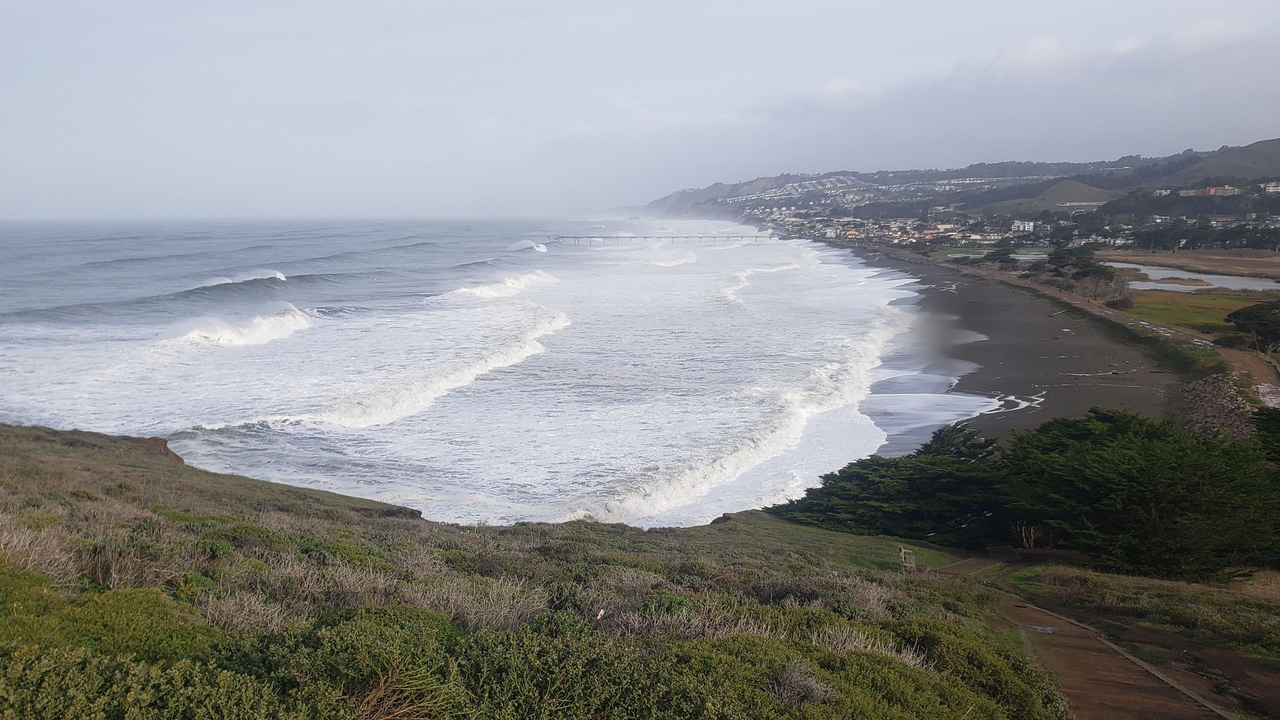 Looking down from the bluffs at Mori Point to waves crashing on the beach.