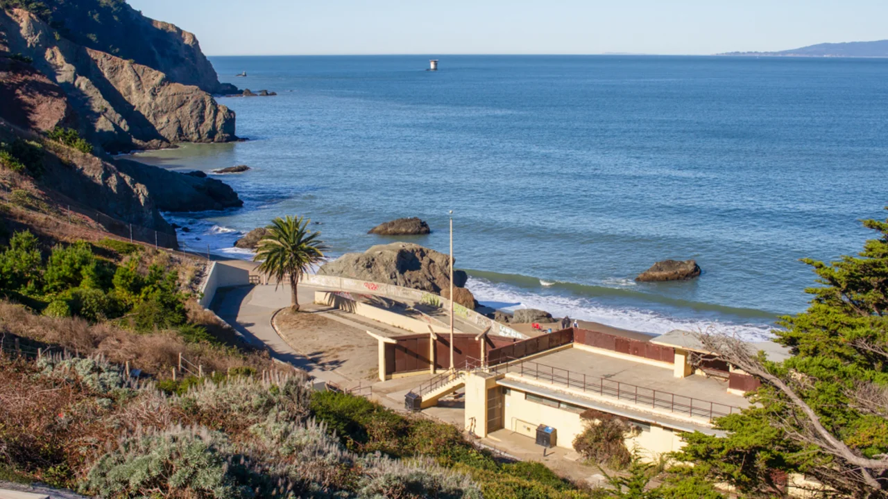 A view of the bathhouse at China Beach, the pacific ocean and marin headlands seen in the background.