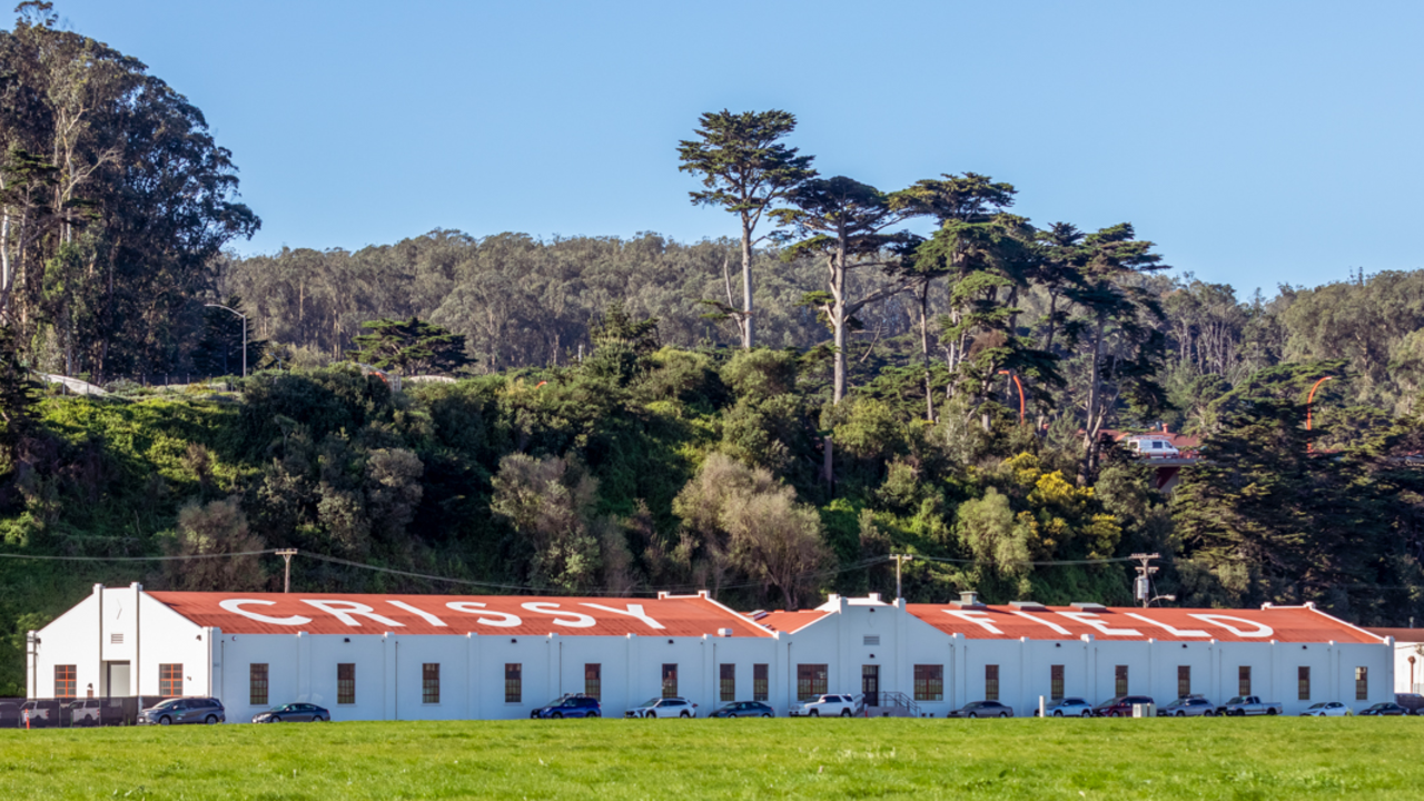 Two historic hangar buildings with the words 'Crissy Field' painted on the roof, a throwback to it's days as an airfield.