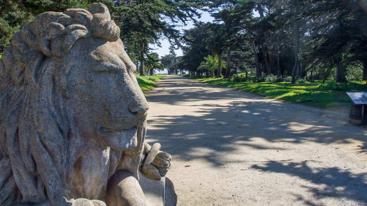 A stone sculpture of a lion seen from a trail at Sutro Heights in San Francisco.